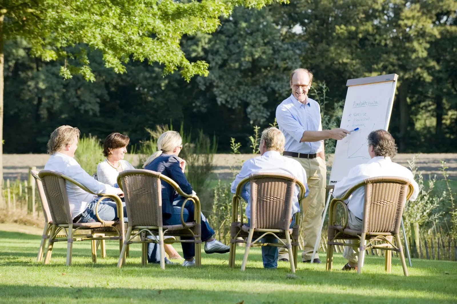 Zakelijke bijeenkomst of teammeeting in de buitenlucht bij groepsaccommodatie.