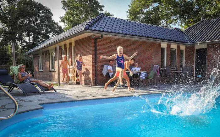 Ferienhaus mit Pool, in dem Kinder während eines Familienurlaubs spielen.