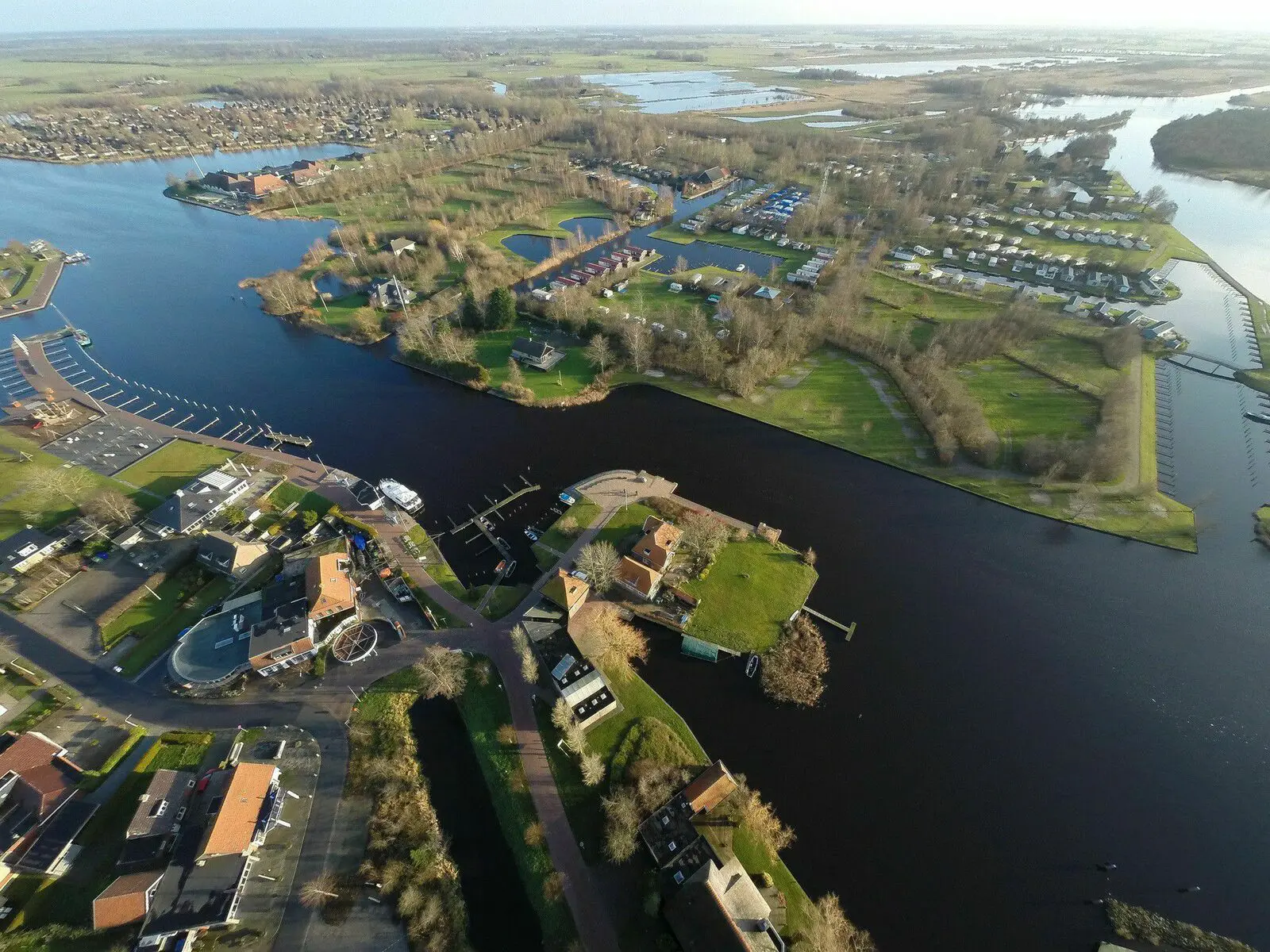 Luftaufnahme eines Ferienparks mit Wasser, Häusern und Natur in Friesland.