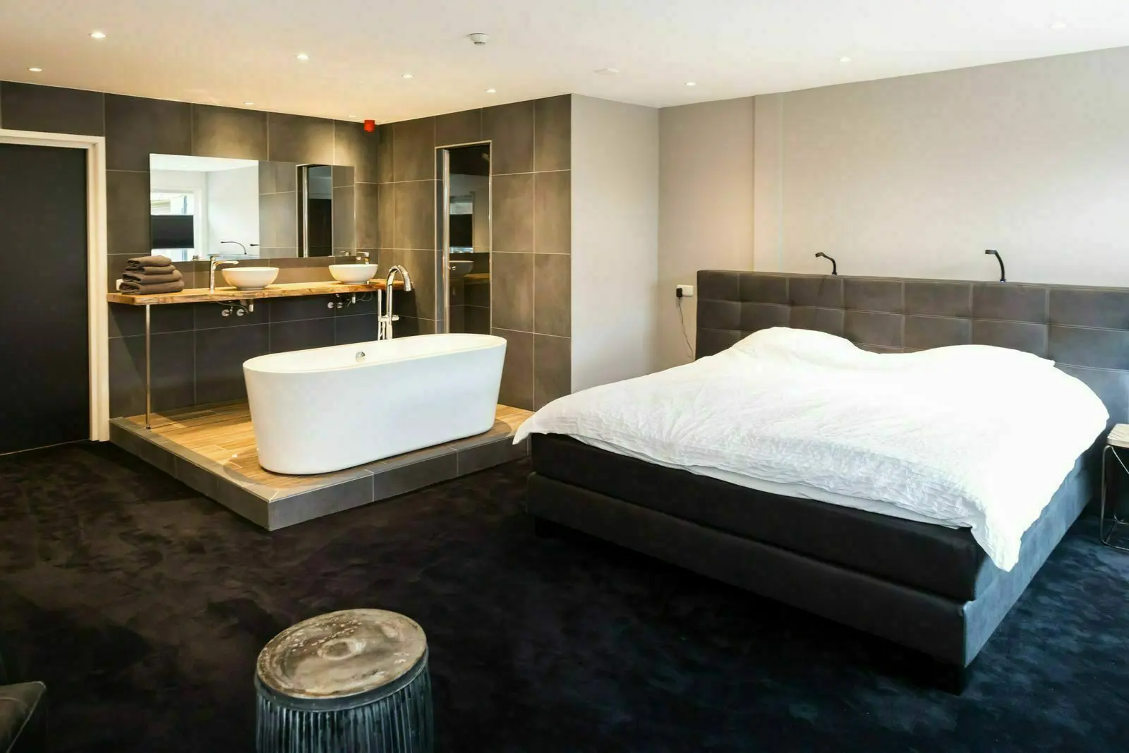 Luxuriöses Schlafzimmer in einer Gruppenunterkunft mit freistehender Badewanne und Doppelwaschbecken.